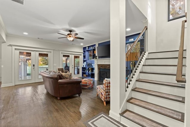 living room featuring french doors, crown molding, built in features, ceiling fan, and wood-type flooring