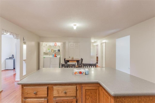 kitchen with independent washer and dryer and light hardwood / wood-style floors