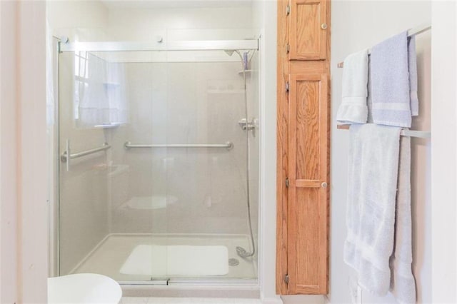 bathroom featuring toilet and an enclosed shower