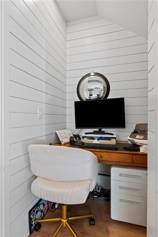 office area with wood finished floors, wooden walls, and vaulted ceiling
