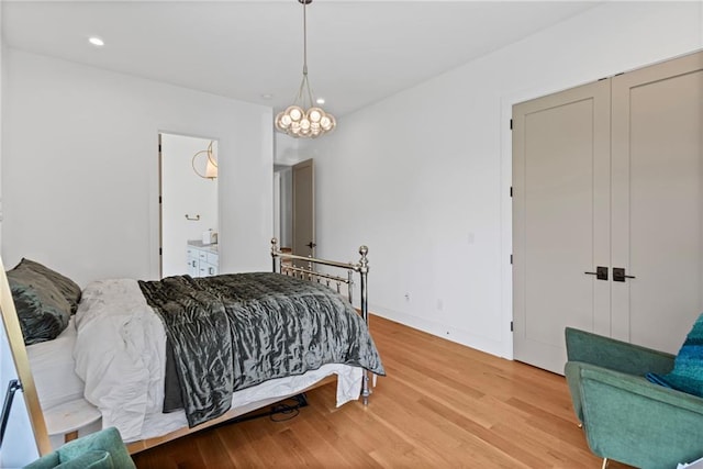 bedroom with a notable chandelier, baseboards, recessed lighting, ensuite bathroom, and light wood finished floors