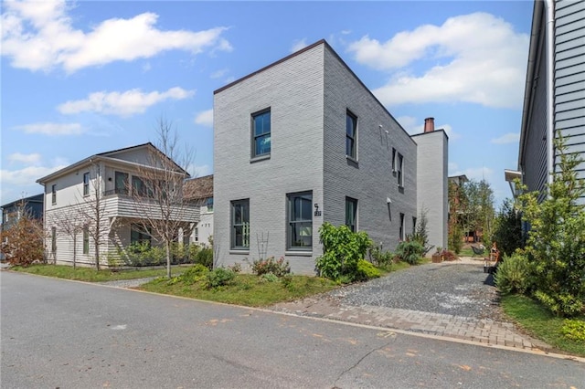 view of side of home with brick siding and driveway