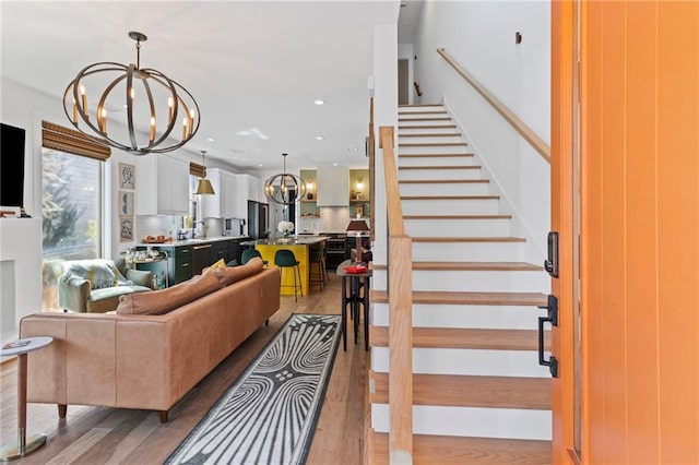 living room featuring light wood-style flooring, stairway, a chandelier, and recessed lighting