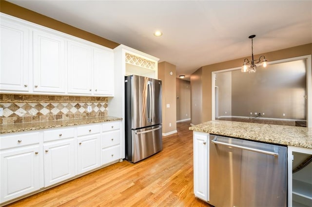 kitchen with white cabinets, decorative backsplash, decorative light fixtures, and appliances with stainless steel finishes