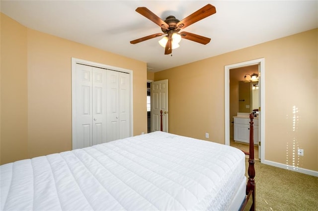 carpeted bedroom featuring ceiling fan, ensuite bathroom, and a closet