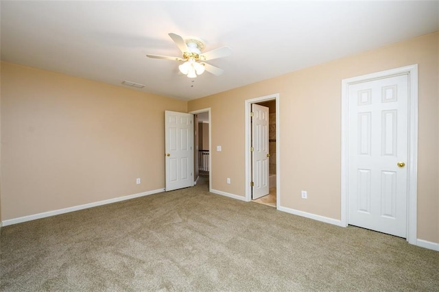 unfurnished bedroom with light carpet, connected bathroom, and ceiling fan