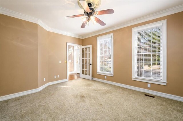 unfurnished room featuring ceiling fan, french doors, light carpet, and ornamental molding