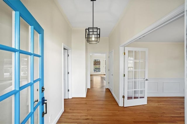 hallway with crown molding, hardwood / wood-style floors, and french doors