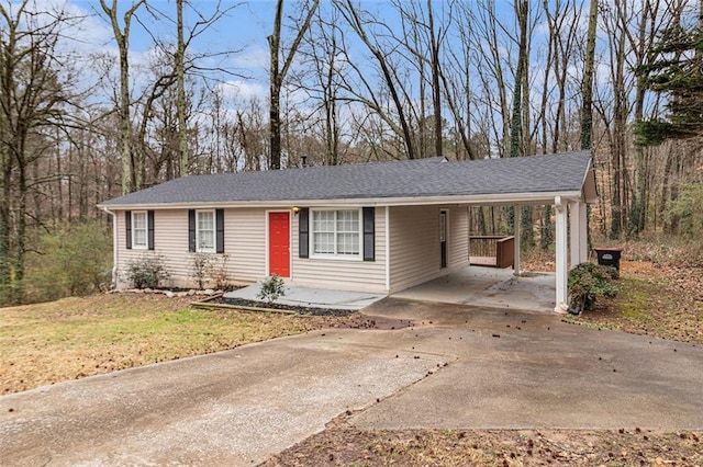 single story home with a carport, a front yard, and driveway