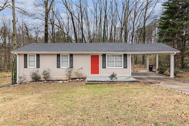 ranch-style house featuring a carport, a front lawn, roof with shingles, and driveway