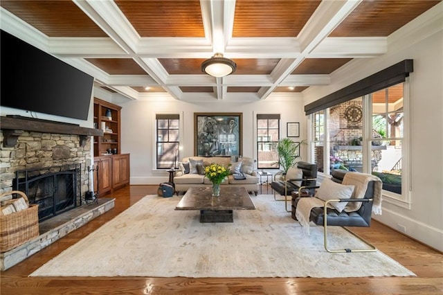 interior space with beam ceiling, a fireplace, wood finished floors, coffered ceiling, and baseboards