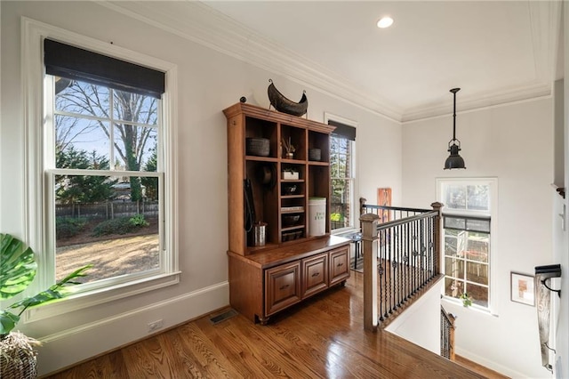 hallway with plenty of natural light, crown molding, baseboards, and dark wood-style flooring