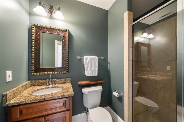 full bath featuring vanity, a shower stall, toilet, and baseboards