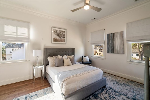 bedroom featuring baseboards, visible vents, ornamental molding, and wood finished floors