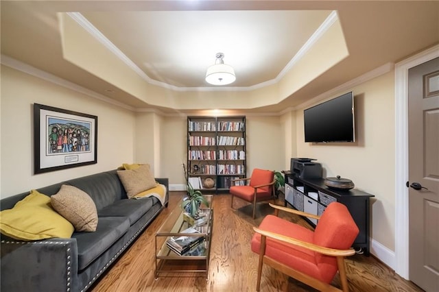 sitting room featuring a tray ceiling, crown molding, baseboards, and wood finished floors