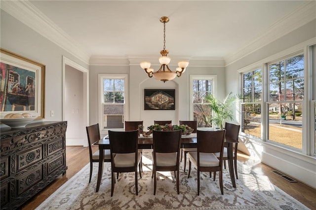 interior space featuring a healthy amount of sunlight, wood finished floors, visible vents, and an inviting chandelier