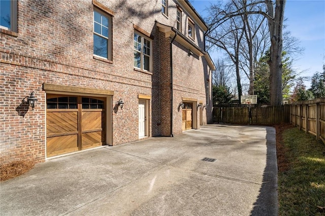 view of home's exterior with brick siding and fence