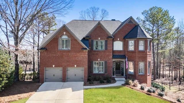 view of front of property with an attached garage, a shingled roof, concrete driveway, a front lawn, and brick siding