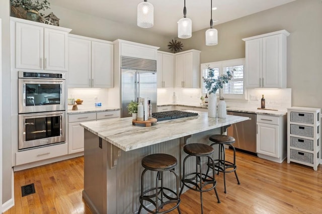 kitchen with white cabinets, light wood-style floors, visible vents, and appliances with stainless steel finishes