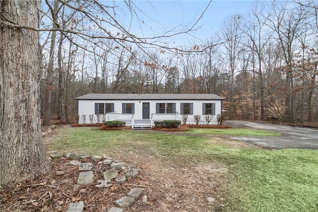 manufactured / mobile home with aphalt driveway and a front yard