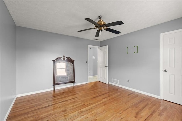 spare room with ceiling fan, a textured ceiling, and hardwood / wood-style floors