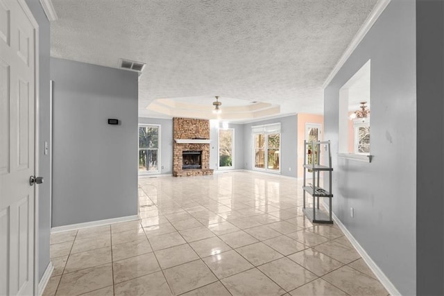 unfurnished living room with a raised ceiling, a fireplace, crown molding, and a textured ceiling