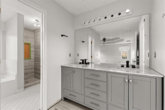 bathroom featuring ceiling fan, vanity, and a tile shower