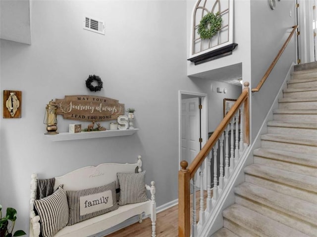 stairway with wood finished floors and baseboards
