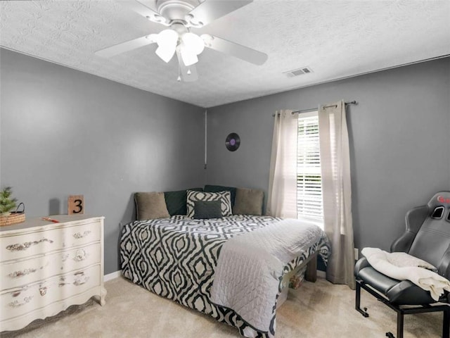 bedroom with carpet flooring, a textured ceiling, and ceiling fan