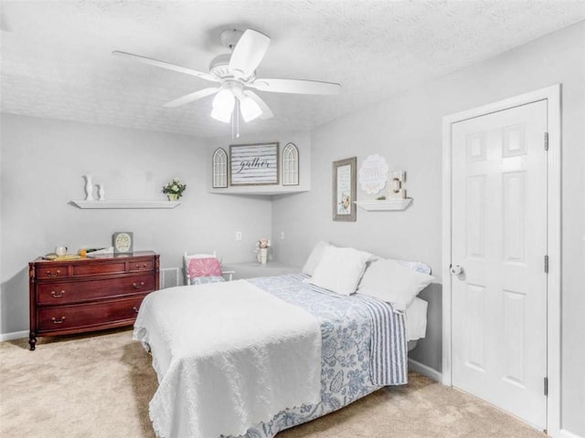 bedroom featuring carpet, a ceiling fan, baseboards, and a textured ceiling