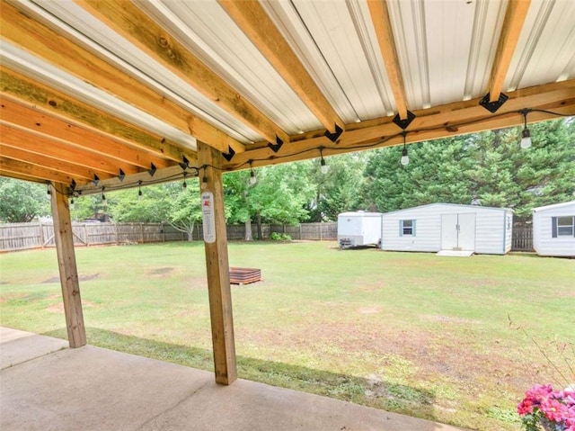 view of yard with a storage shed, a patio area, and an outbuilding
