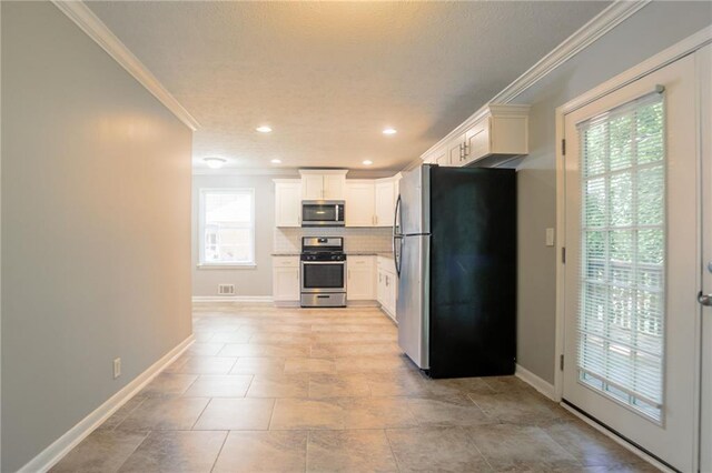 802 San Miguel Dr, Stone Mountain, GA 30083 - kitchen featuring stainless steel appliances, crown molding, baseboards, backsplash, and white cabinetry