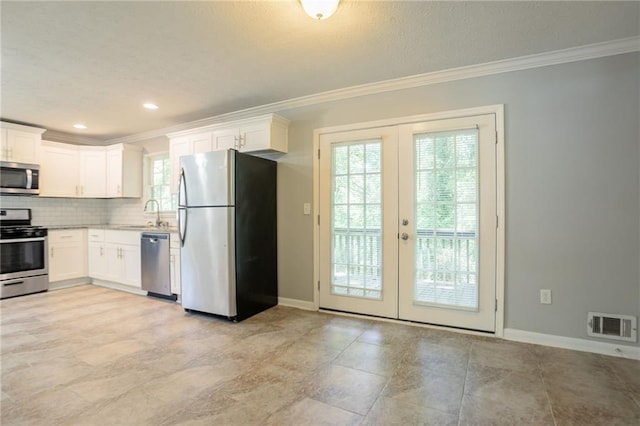 802 San Miguel Dr, Stone Mountain, GA 30083 - kitchen with appliances with stainless steel finishes, french doors, crown molding, backsplash, and white cabinets
