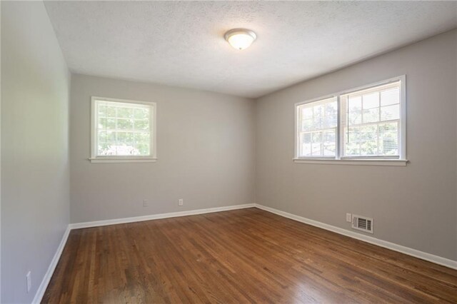 802 San Miguel Dr, Stone Mountain, GA 30083 - unfurnished room with dark wood finished floors, baseboards, and a textured ceiling