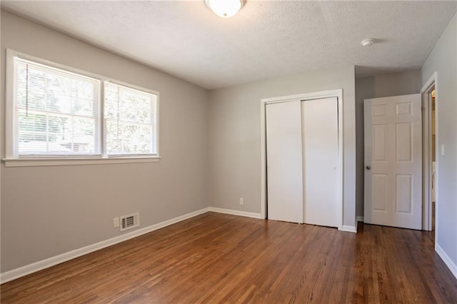 802 San Miguel Dr, Stone Mountain, GA 30083 - unfurnished bedroom featuring wood finished floors, baseboards, a closet, and a textured ceiling