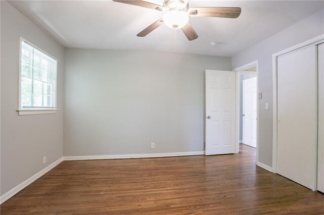 802 San Miguel Dr, Stone Mountain, GA 30083 - unfurnished bedroom with wood finished floors, baseboards, a closet, and ceiling fan