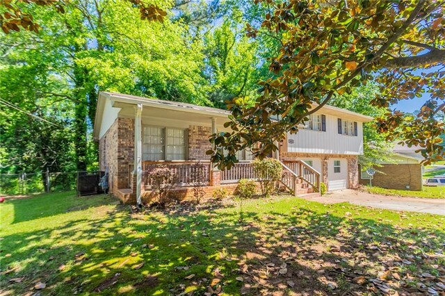 802 San Miguel Dr, Stone Mountain, GA 30083 - view of front of house with brick siding, a porch, and cooling unit
