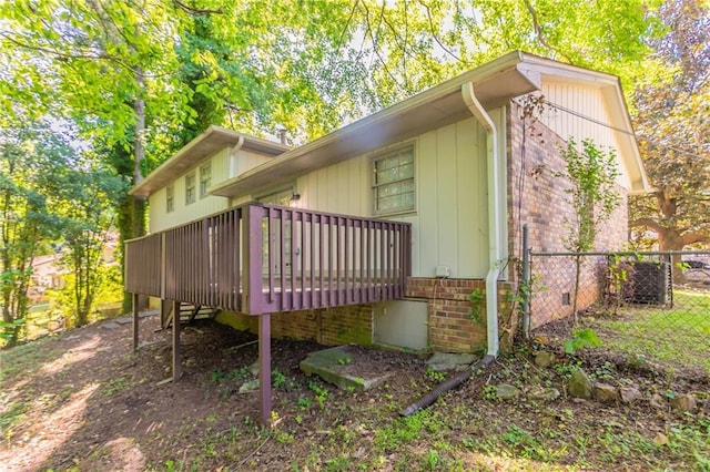 802 San Miguel Dr, Stone Mountain, GA 30083 - view of home's exterior with a wooden deck, fence, and brick siding