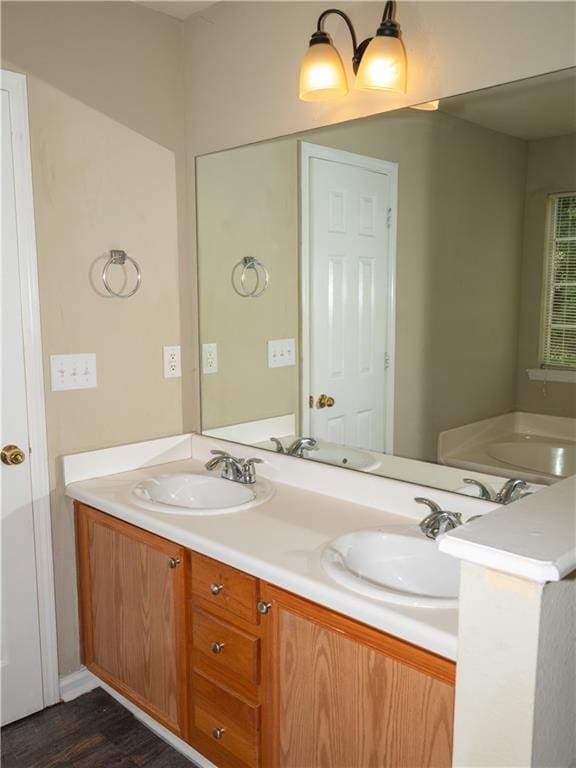 full bathroom with wood finished floors, a sink, and double vanity