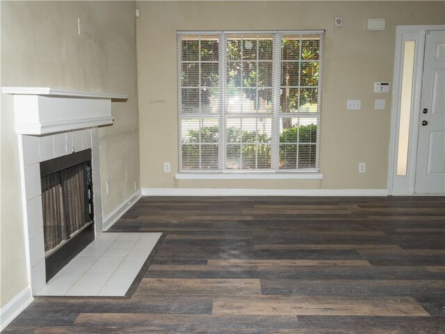 unfurnished living room featuring hardwood / wood-style flooring and a tile fireplace