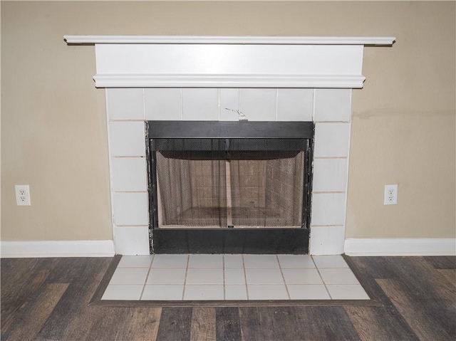 room details with baseboards, wood finished floors, and a tile fireplace