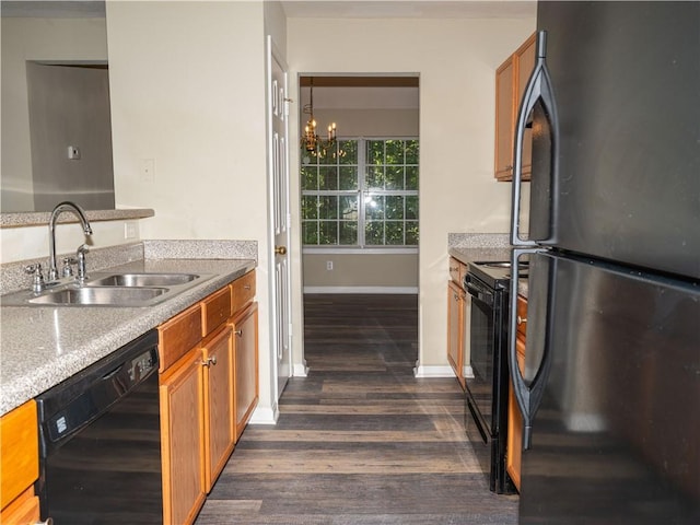 kitchen featuring brown cabinetry, dark wood-style flooring, light countertops, black appliances, and a sink