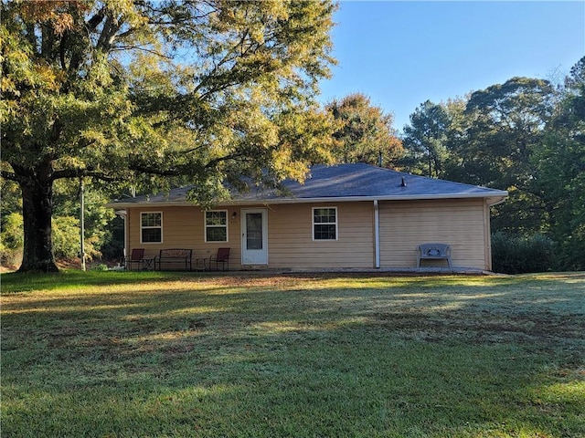 rear view of house featuring a lawn