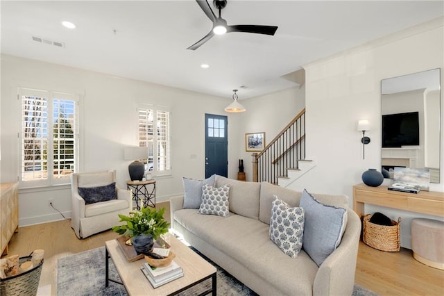 living room featuring ceiling fan and light hardwood / wood-style flooring