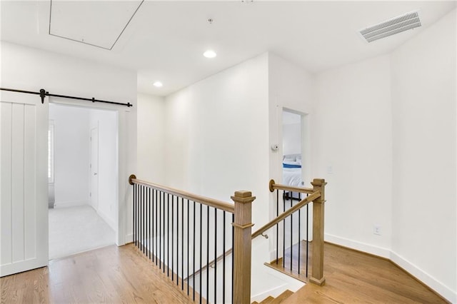 hallway with hardwood / wood-style flooring and a barn door