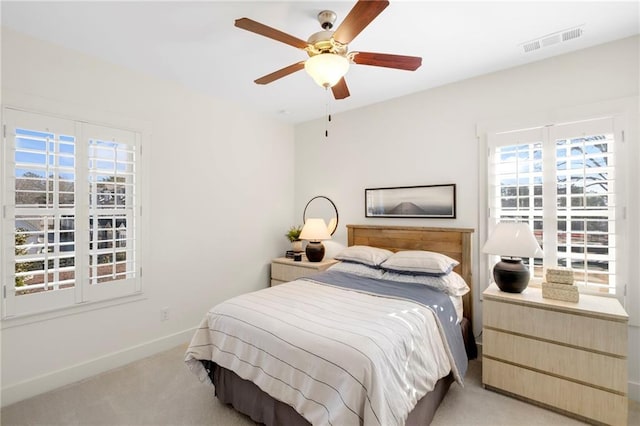 bedroom with ceiling fan and light colored carpet