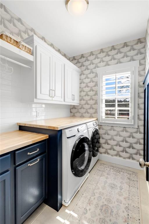 laundry room with cabinets and washing machine and clothes dryer