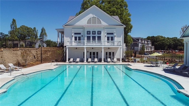 rear view of house with a community pool, a patio area, and ceiling fan