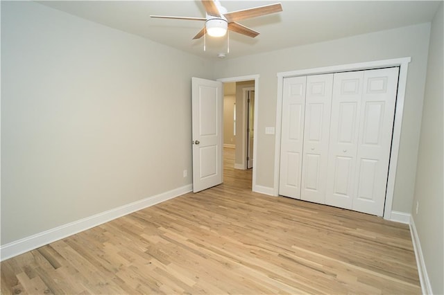 unfurnished bedroom featuring a closet, light hardwood / wood-style flooring, and ceiling fan