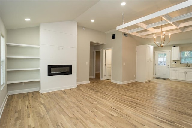 unfurnished living room with beamed ceiling, light hardwood / wood-style floors, a chandelier, and coffered ceiling